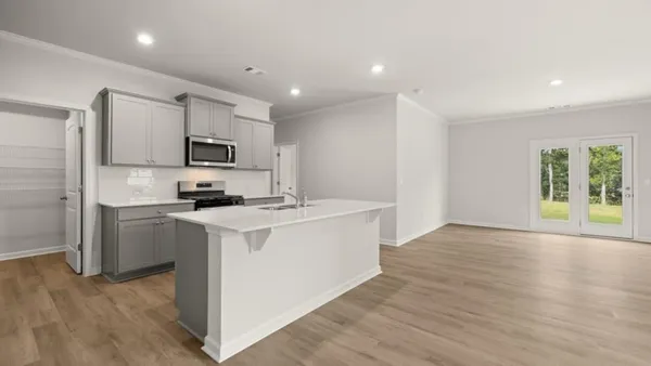 a kitchen with kitchen island a sink a stove a microwave and wooden floor