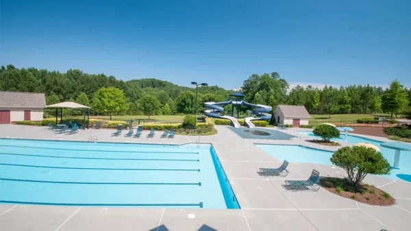 a view of swimming pool with outdoor seating and a garden