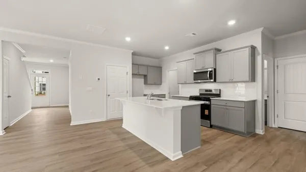 a kitchen with a sink cabinets and wooden floor