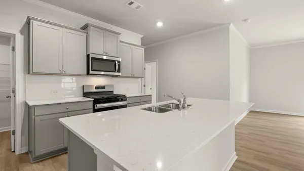 a kitchen with stainless steel appliances a stove a sink a microwave and cabinets