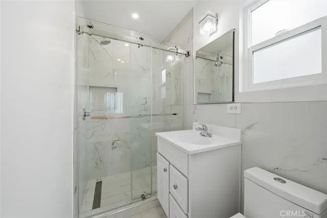a bathroom with a sink toilet vanity and shower