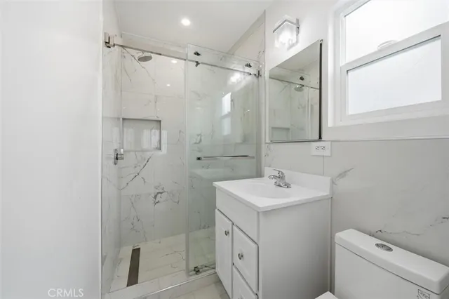 a bathroom with a sink toilet vanity and shower