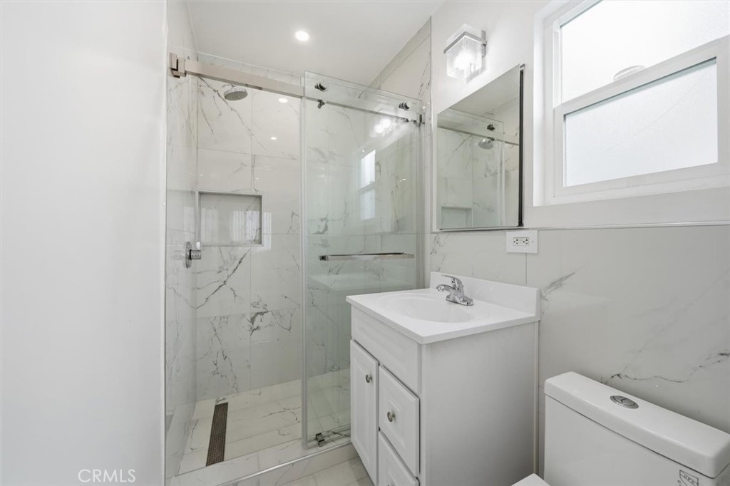 220 39th Street, Unit B Manhattan Beach, CA 90266 - Photo 15 of 21 a bathroom with a sink toilet vanity and shower