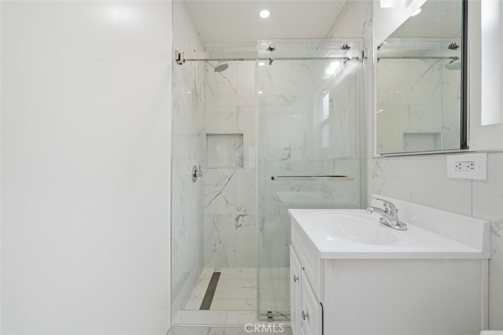 220 39th Street, Unit B Manhattan Beach, CA 90266 - Photo 16 of 21 a bathroom with a sink a glass door shower and a mirror