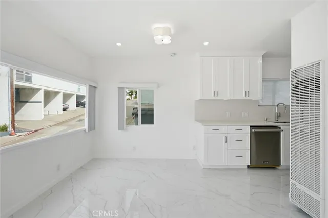 a kitchen with granite countertop white cabinets and refrigerator