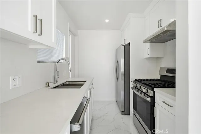 a kitchen with granite countertop a sink stove and refrigerator