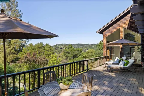 a view of balcony with furniture and umbrella