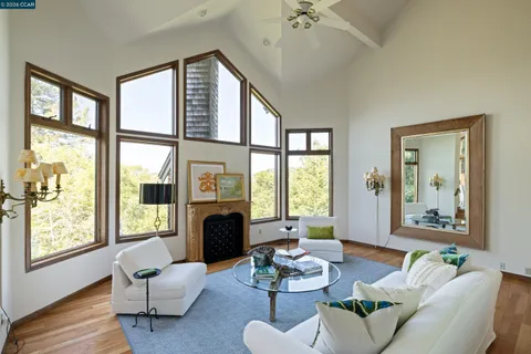 a living room with furniture large window and wooden floor