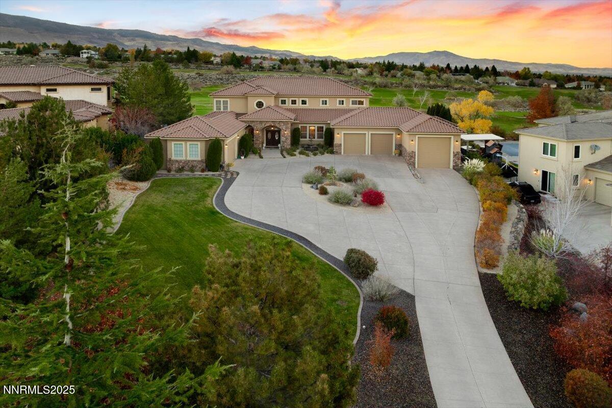 an aerial view of a house with a garden and lake view