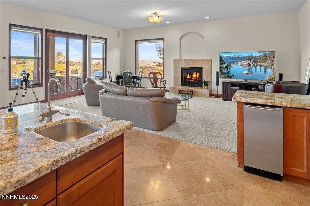 13005 Silver Wolf Road Reno, NV 89511 - Photo 23 of 40 a living room with furniture a fireplace and a large window