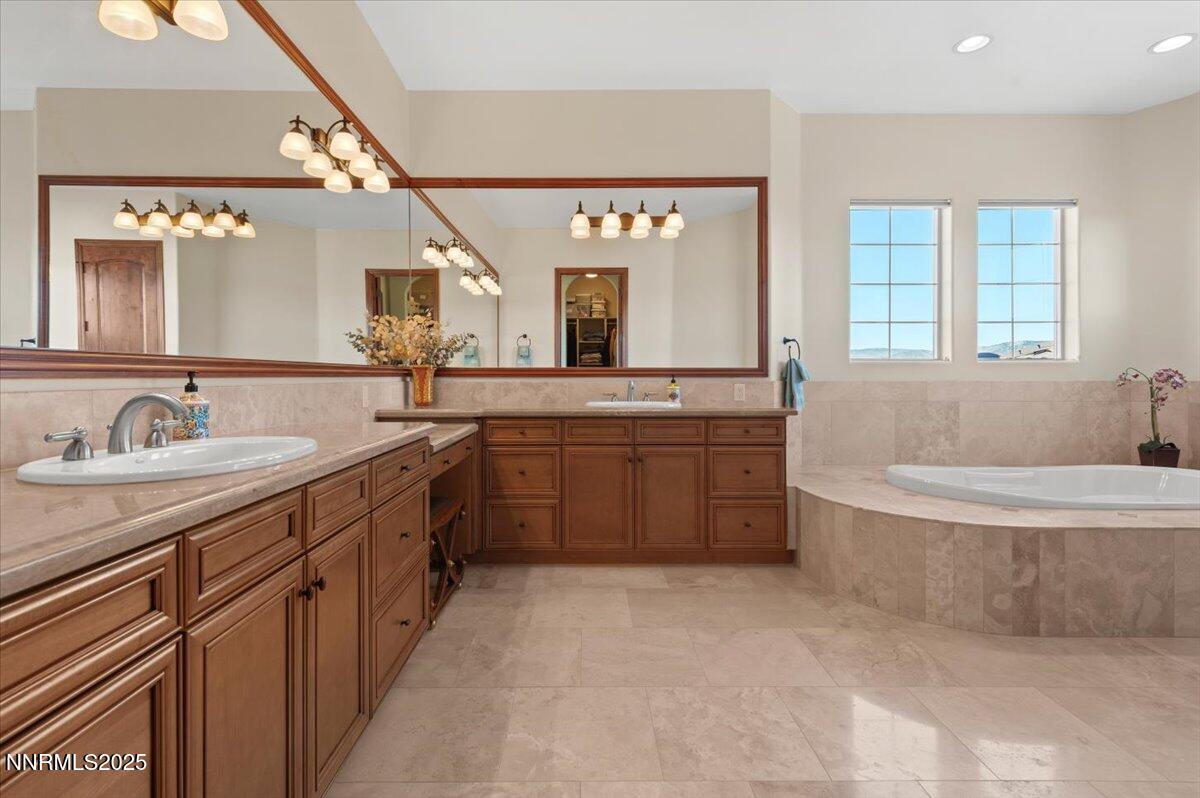 13005 Silver Wolf Road Reno, NV 89511 - Photo 28 of 40 a spacious bathroom with a granite countertop double vanity sink a mirror and a bathtub