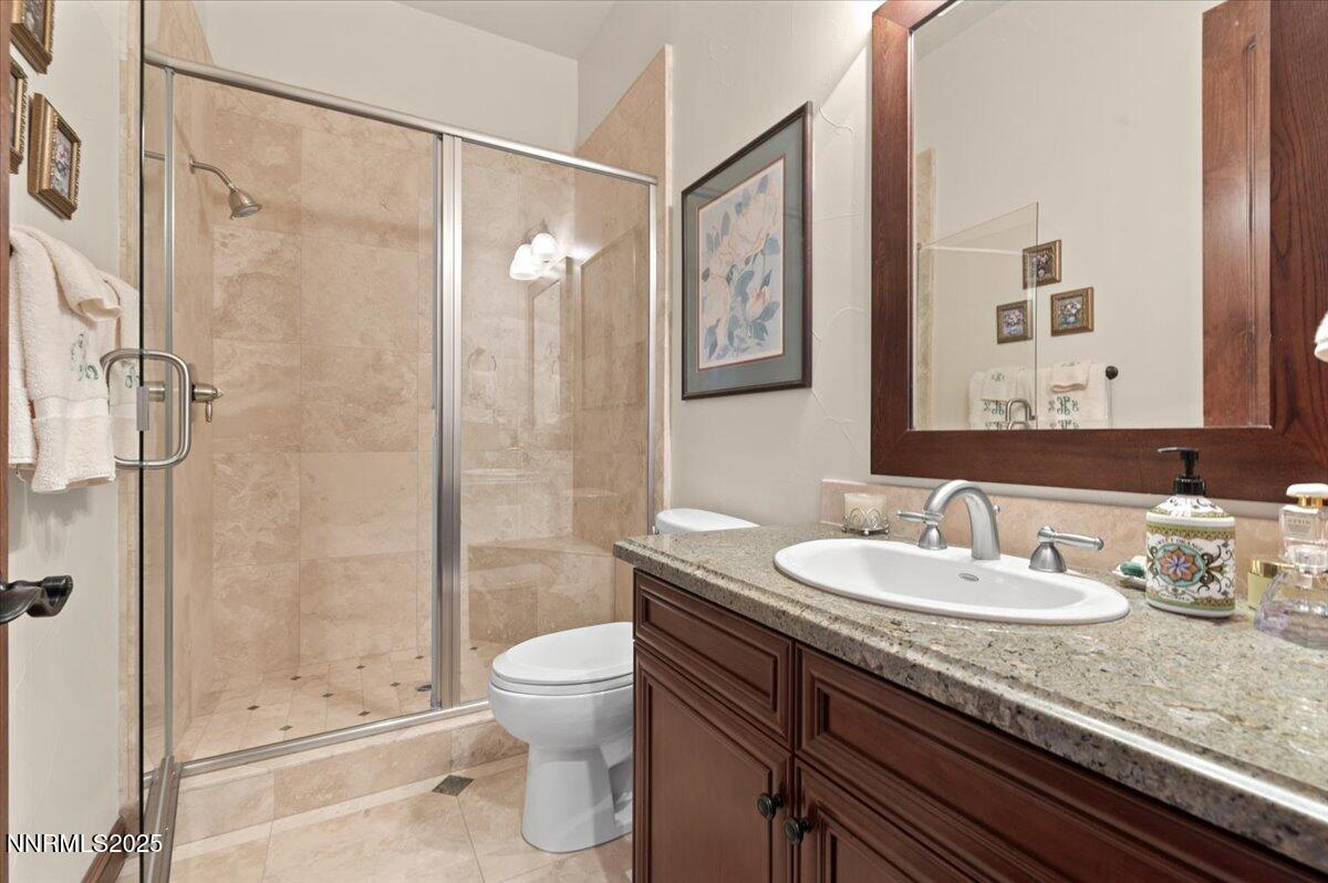 13005 Silver Wolf Road Reno, NV 89511 - Photo 35 of 40 a bathroom with a granite countertop sink a toilet and shower