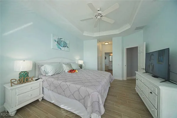 a bedroom with a large bed a flat tv screen and dresser