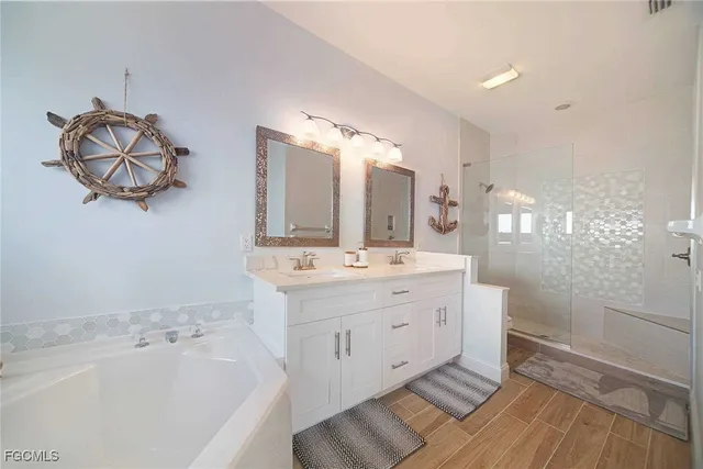 a bathroom with a double vanity sink mirror and bathtub