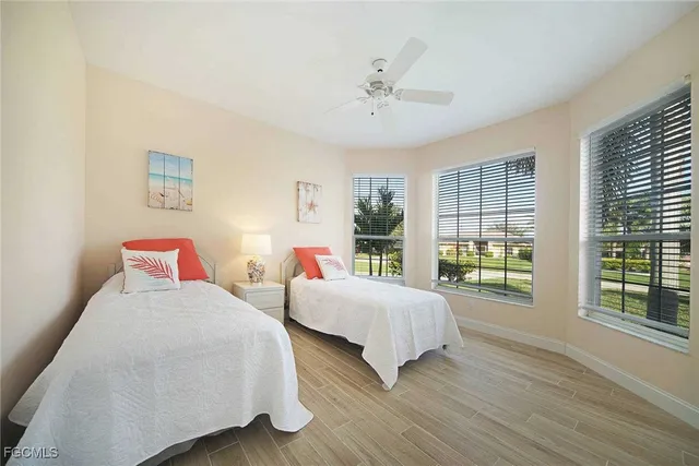 a bedroom with two beds and a large window