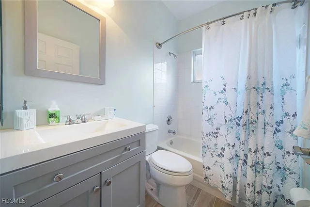 a bathroom with a sink a toilet and shower curtain