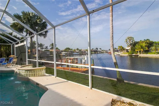 a view of a lake with a floor to ceiling window next to a yard