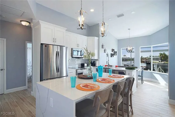 a dining room with stainless steel appliances kitchen island granite countertop a dining table and chairs