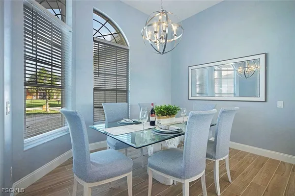 a view of a dining room with furniture a chandelier and wooden floor