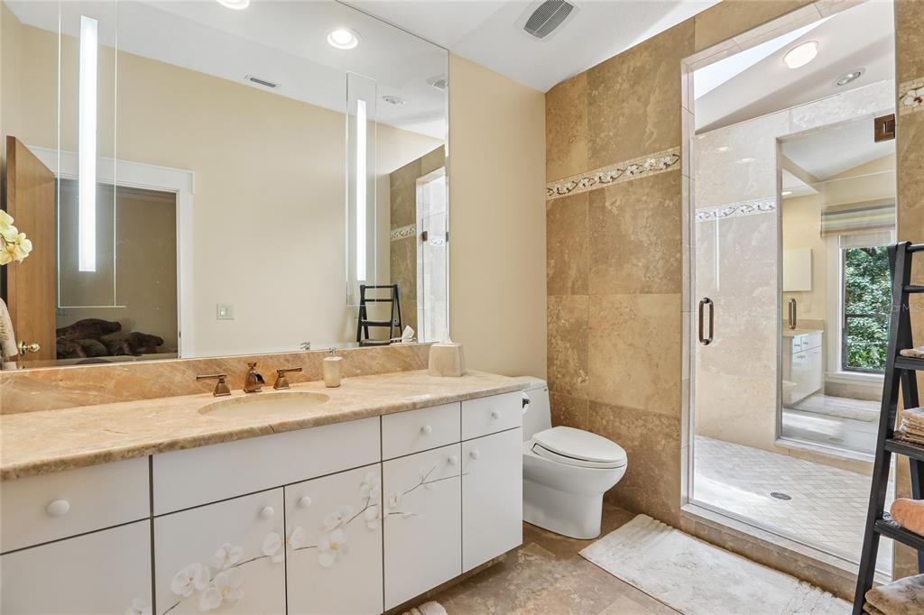 17810 Crawley Road Odessa, FL 33556 - Photo 37 of 76 a spacious bathroom with a double vanity sink toilet mirror and shower