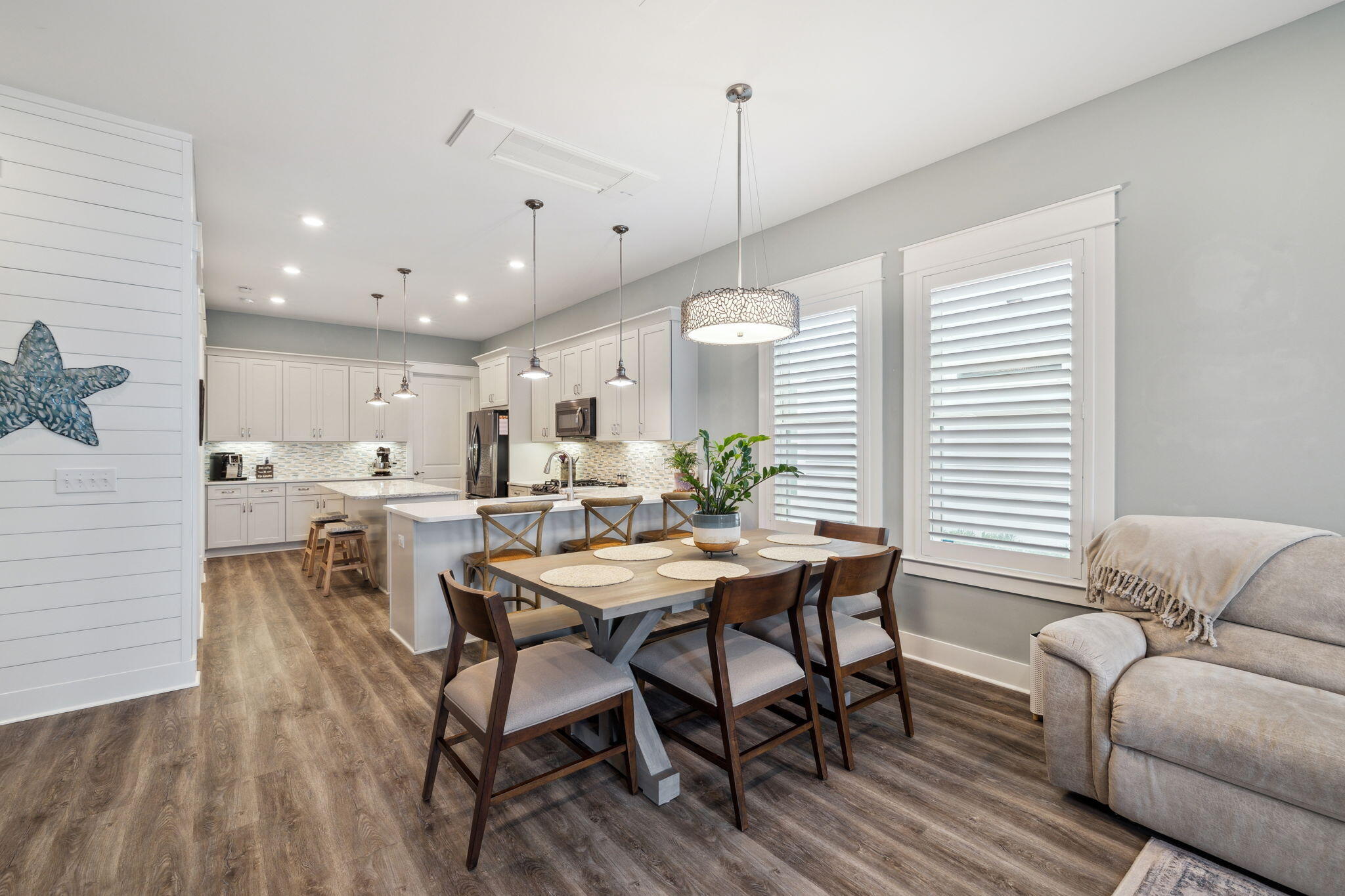 38 Constant Avenue Santa Rosa Beach, FL 32459 - Photo 7 of 36 a view of a dining room and livingroom with furniture wooden floor a rug a potted plant and a chandelier