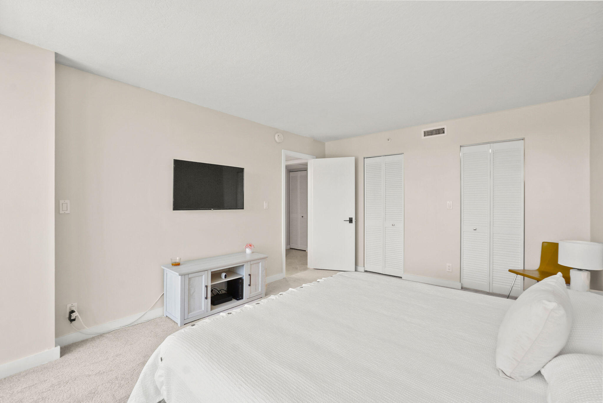 3440 South Ocean Boulevard, Unit 105S Palm Beach, FL 33480 - Photo 22 of 77 a bedroom with a bed and a flat screen tv