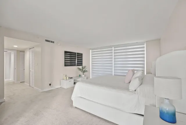 a view of a hallway with bathroom and a glass door shower