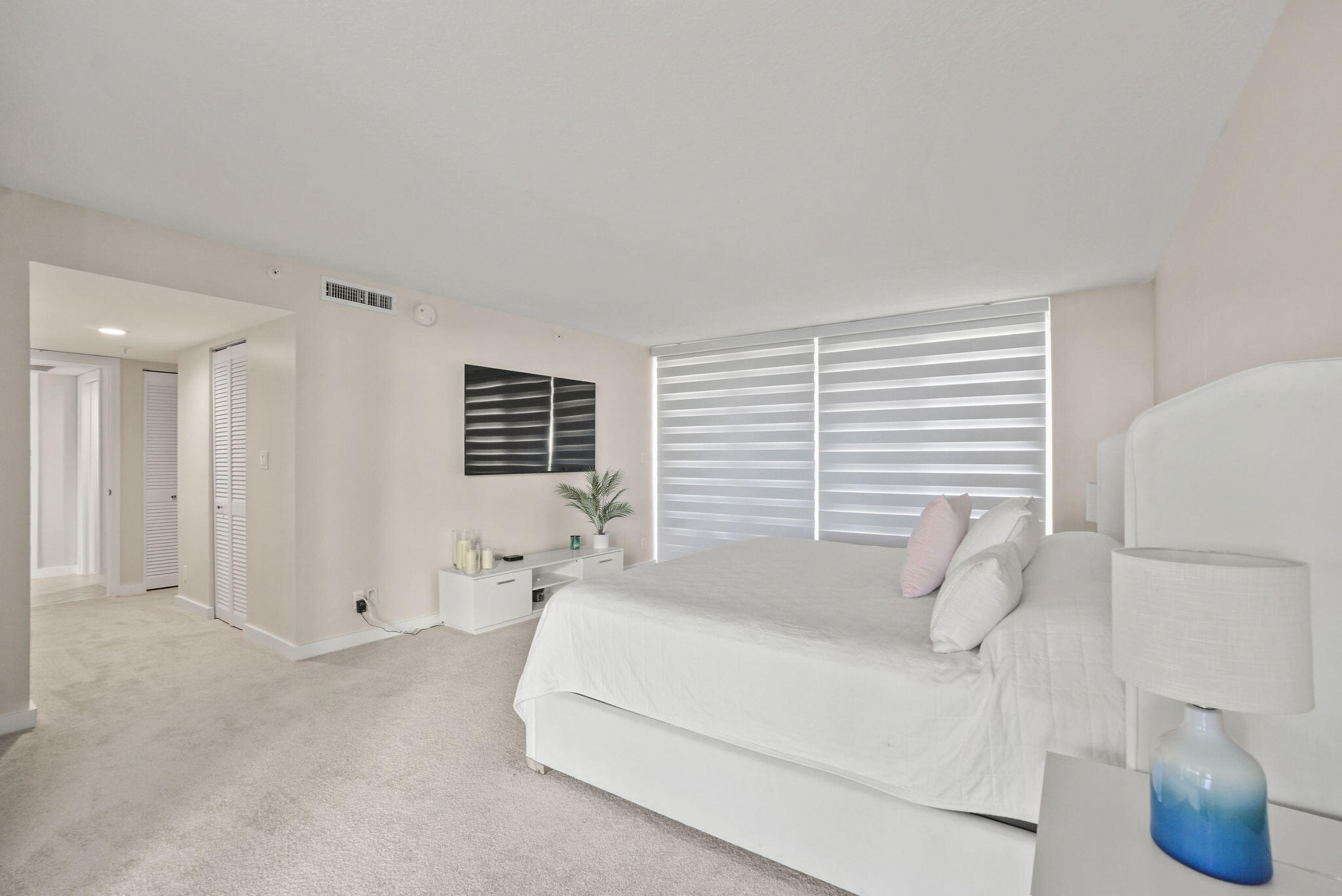 3440 South Ocean Boulevard, Unit 105S Palm Beach, FL 33480 - Photo 30 of 77 a spacious bedroom with a bed and a large window