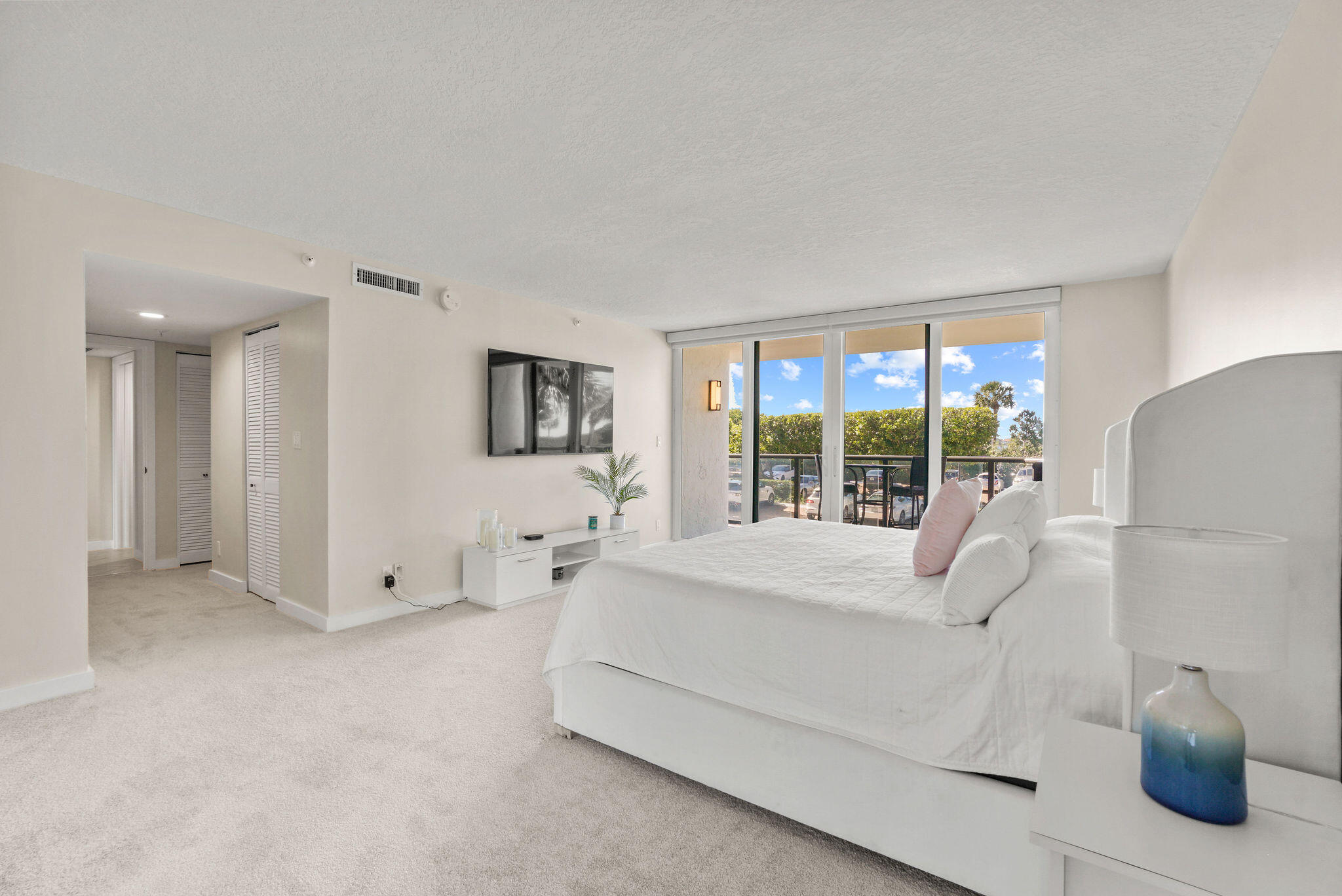 3440 South Ocean Boulevard, Unit 105S Palm Beach, FL 33480 - Photo 31 of 77 a spacious bedroom with a bed and a large window