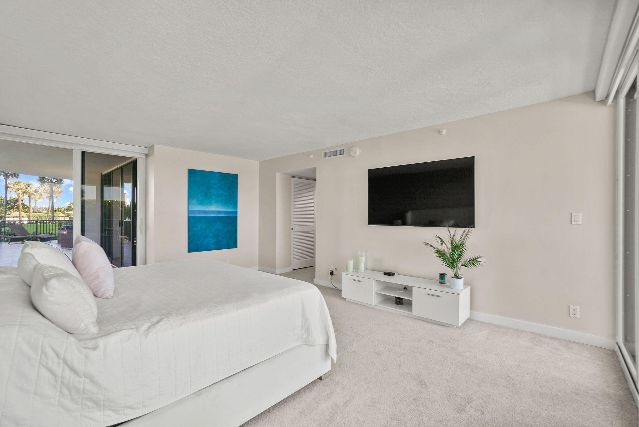 3440 South Ocean Boulevard, Unit 105S Palm Beach, FL 33480 - Photo 33 of 77 a bedroom with a bed and a flat screen tv