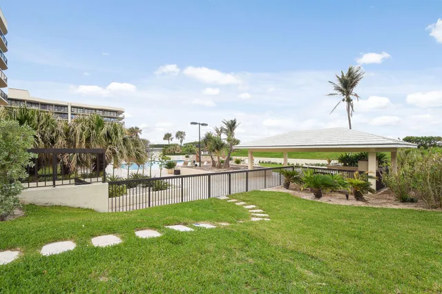 a view of a tall building with a yard and plants