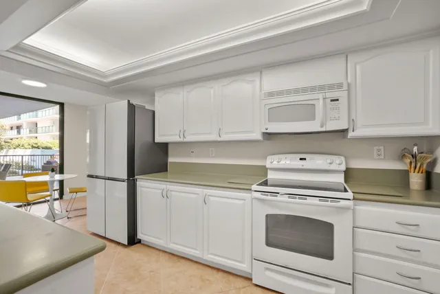 a kitchen with stainless steel appliances granite countertop a sink and dishwasher with white cabinets
