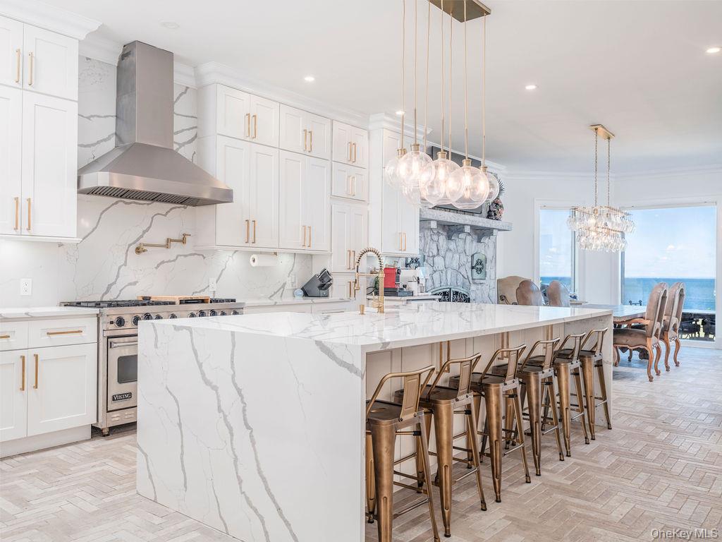 3875 Hallock Lane Mattituck, NY 11952 - Photo 11 of 50 Kitchen featuring backsplash, wall chimney range hood, light stone counters, luxury range, and decorative light fixtures