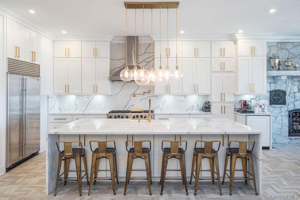 3875 Hallock Lane Mattituck, NY 11952 - Photo 12 of 50 Kitchen featuring a breakfast bar, light stone countertops, pendant lighting, stainless steel built in refrigerator, and ornamental molding