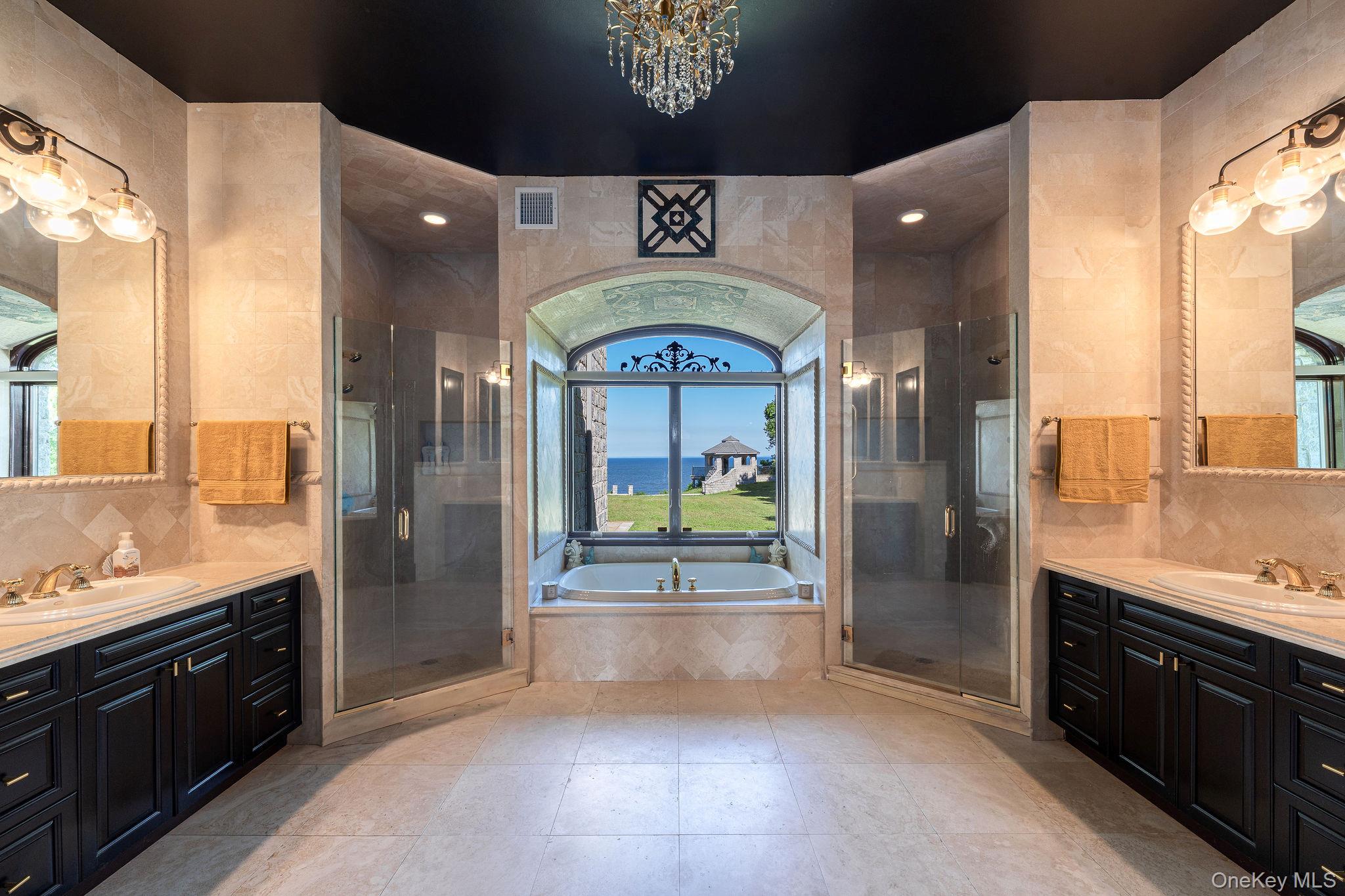3875 Hallock Lane Mattituck, NY 11952 - Photo 21 of 50 Bathroom featuring tile walls, a bath, a stall shower, two vanities, and backsplash