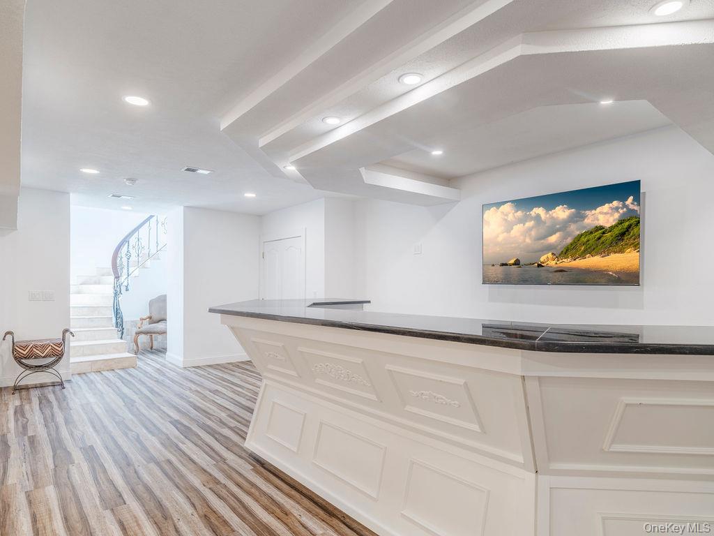 3875 Hallock Lane Mattituck, NY 11952 - Photo 31 of 50 Kitchen with light wood-type flooring, dark stone countertops, recessed lighting, and white cabinetry