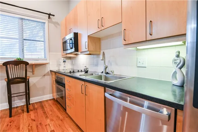 a kitchen with stainless steel appliances granite countertop a sink and a microwave