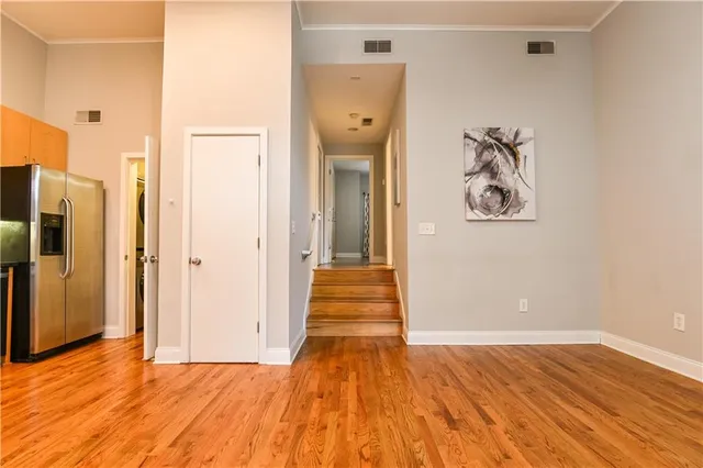 a view of a hallway with wooden floor and closet