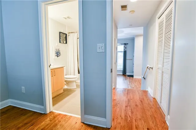 a view of a hallway with wooden floor and a living room
