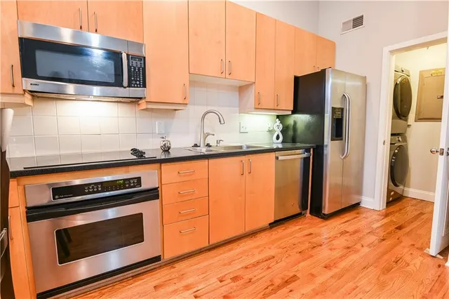 a kitchen with granite countertop a sink stove and refrigerator