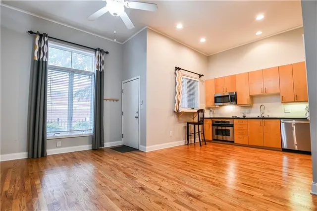 a large kitchen with stainless steel appliances granite countertop a refrigerator and a stove top oven