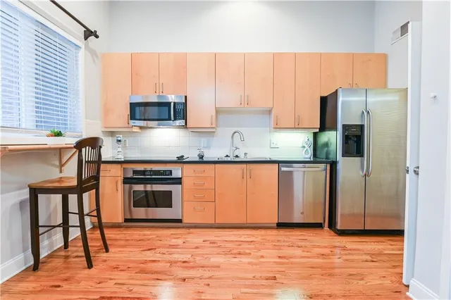 a kitchen with stainless steel appliances granite countertop a stove a sink and a refrigerator