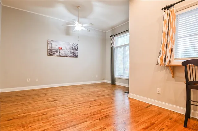 a view of an empty room with window and wooden floor