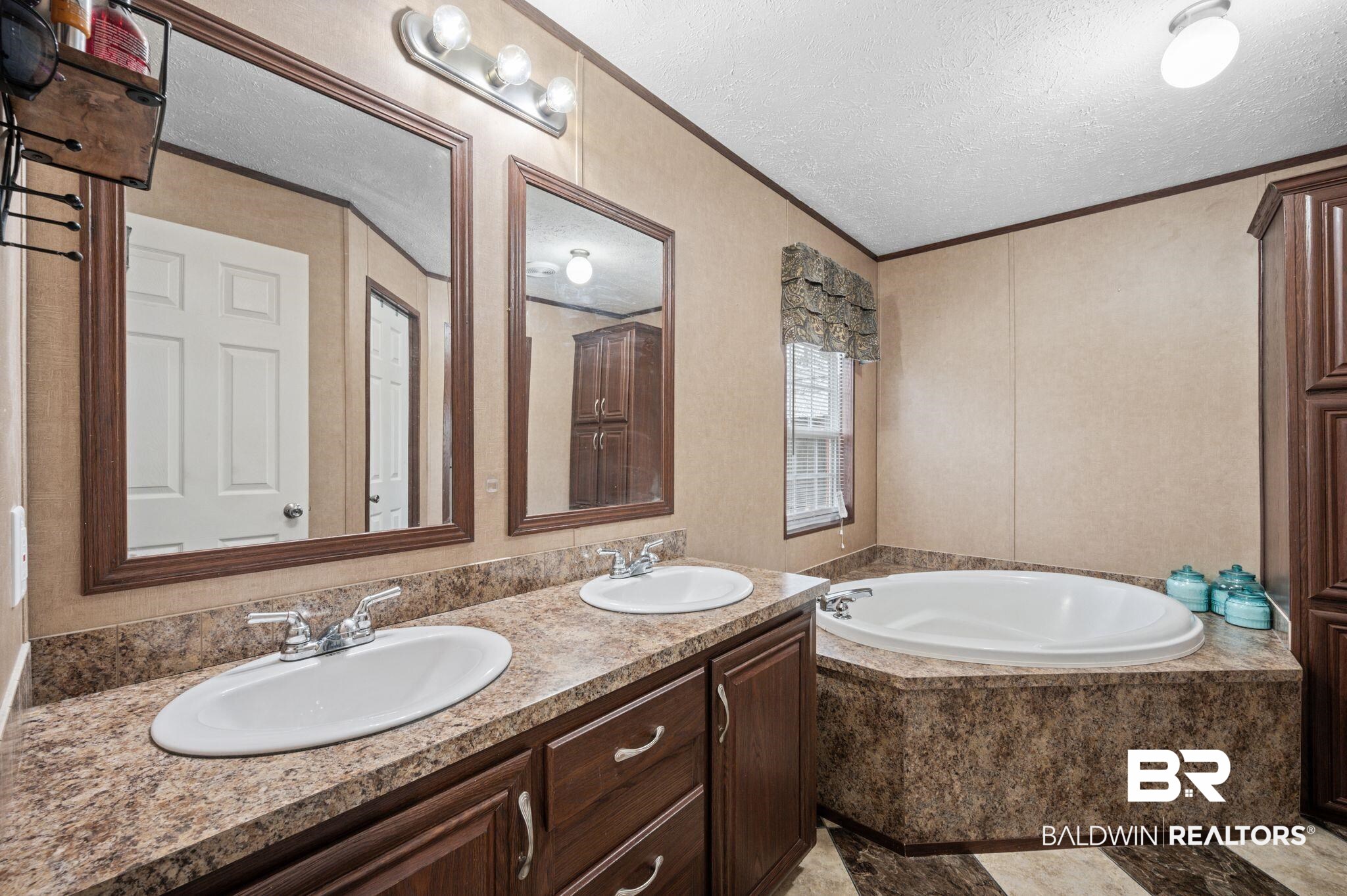 39908 T A Chastang Road Bay Minette, AL 36507 - Photo 11 of 20 Full bath featuring a garden tub, a textured ceiling, ornamental molding, and a sink
