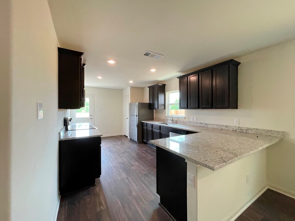 168 Allington Circle Jarrell, TX 76537 - Photo 11 of 40 a kitchen with stainless steel appliances granite countertop a sink and a stove