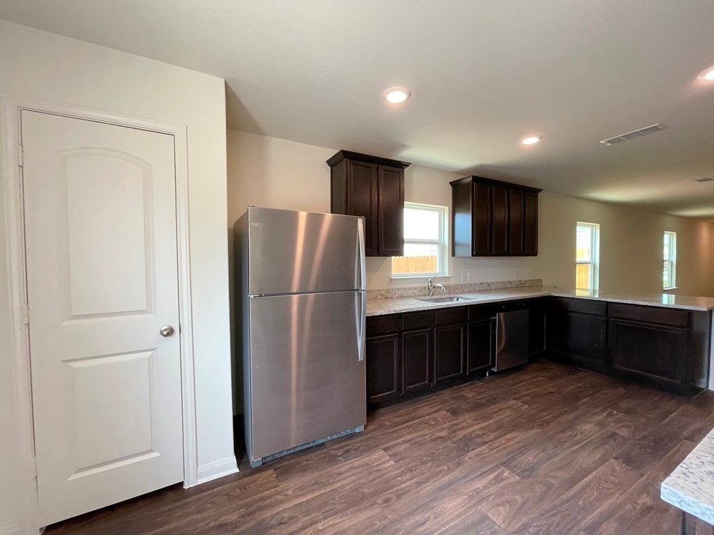 168 Allington Circle Jarrell, TX 76537 - Photo 13 of 40 a kitchen with a refrigerator and a sink