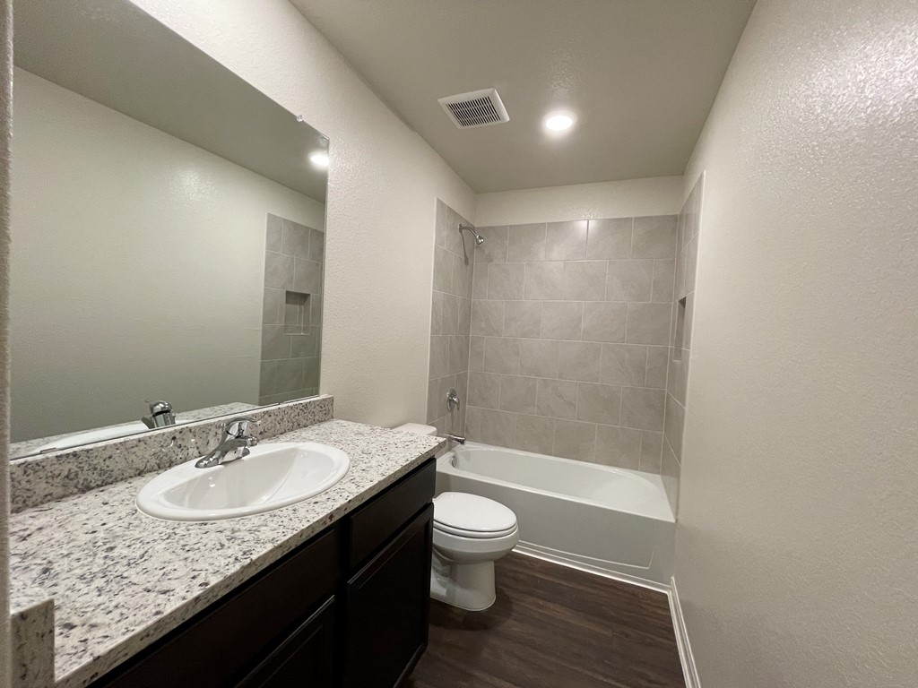 168 Allington Circle Jarrell, TX 76537 - Photo 26 of 40 a bathroom with a granite countertop sink a toilet and shower