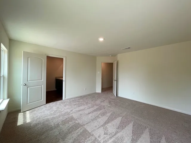 a bedroom with a large bed and a chandelier