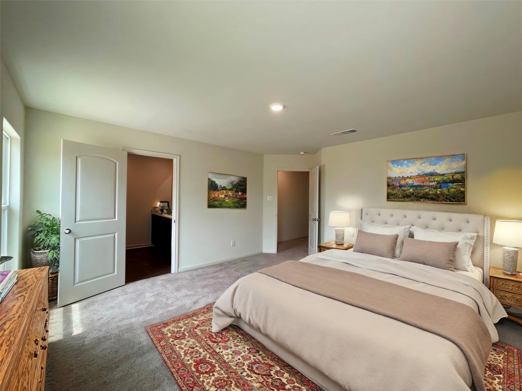 168 Allington Circle Jarrell, TX 76537 - Photo 30 of 40 a bedroom with a large bed and a chandelier