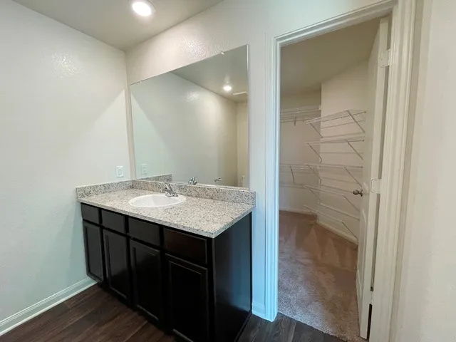 a bathroom with a granite countertop sink a toilet and bathtub